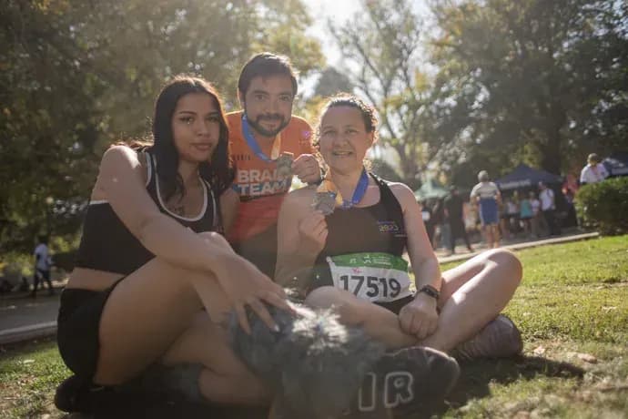 Macarena corriendo en una competencia al aire libre, de día, entre otros participantes.