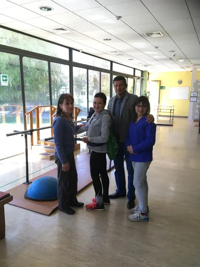 Macarena junto a su equipo médico en una sala de rehabilitación, todos de pie mirando a la cámara.