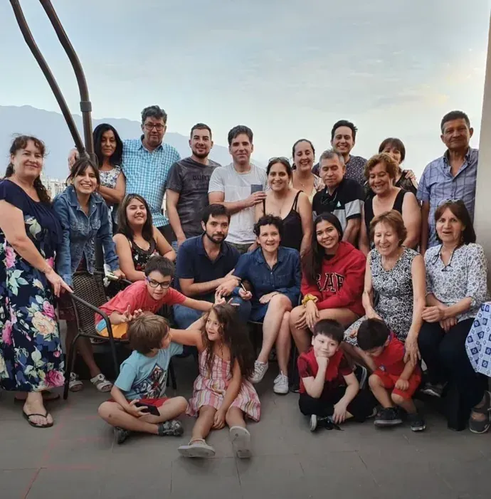 La familia de Macarena reunida en una terraza, más de veinte personas de todas las edades posando juntas.