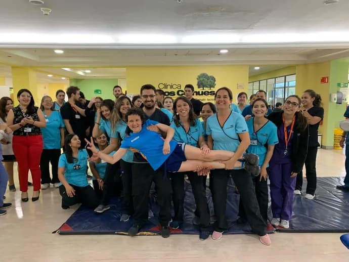 Macarena en brazos de su equipo de rehabilitación de la Clínica Los Coihues, rodeada por el resto del equipo